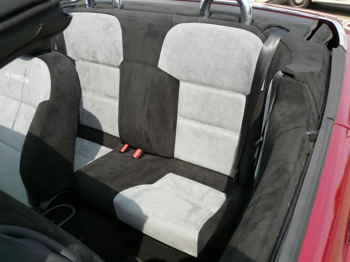 Der Rücksitz eines roten Autos mit einem schwarz-weißen Sitz