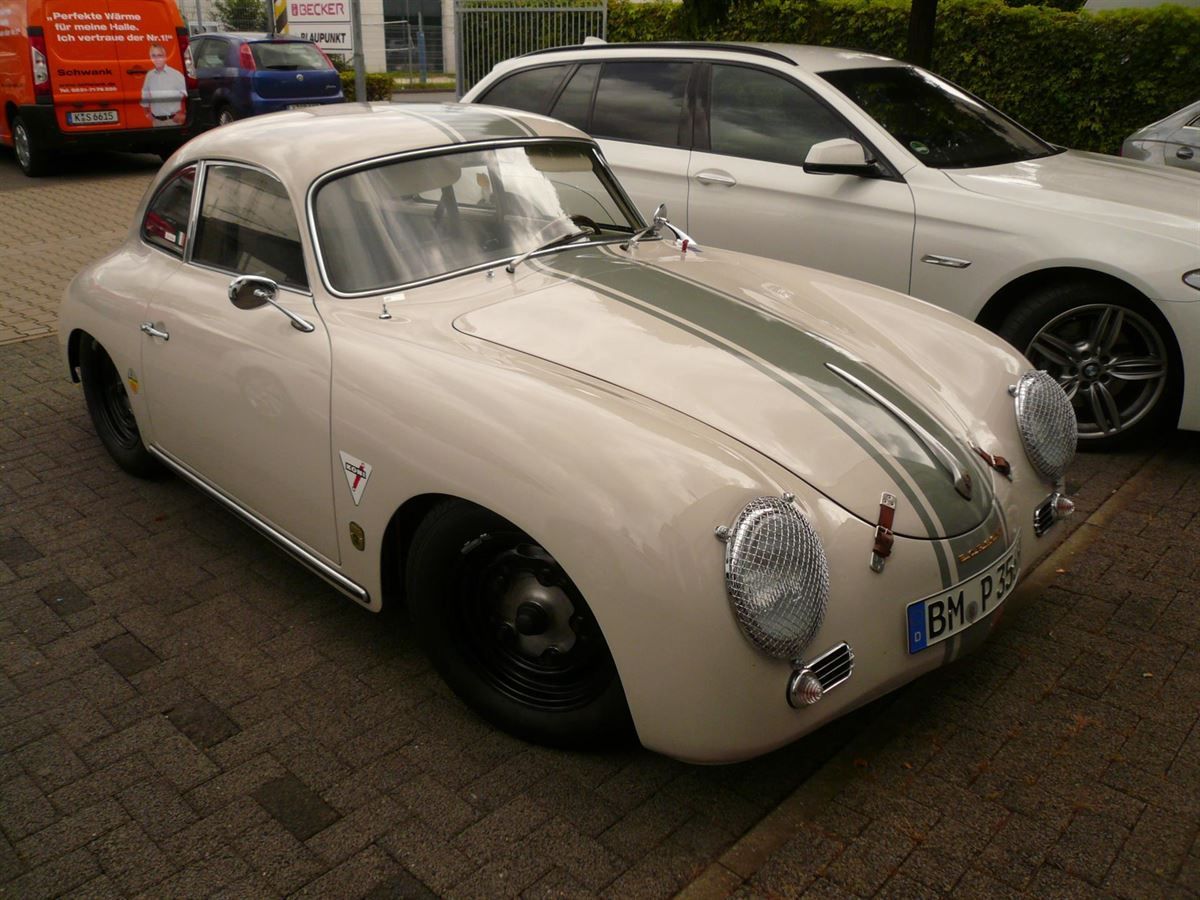 Ein weißes Auto mit einem grünen Streifen an der Seite ist neben einem weißen Auto geparkt