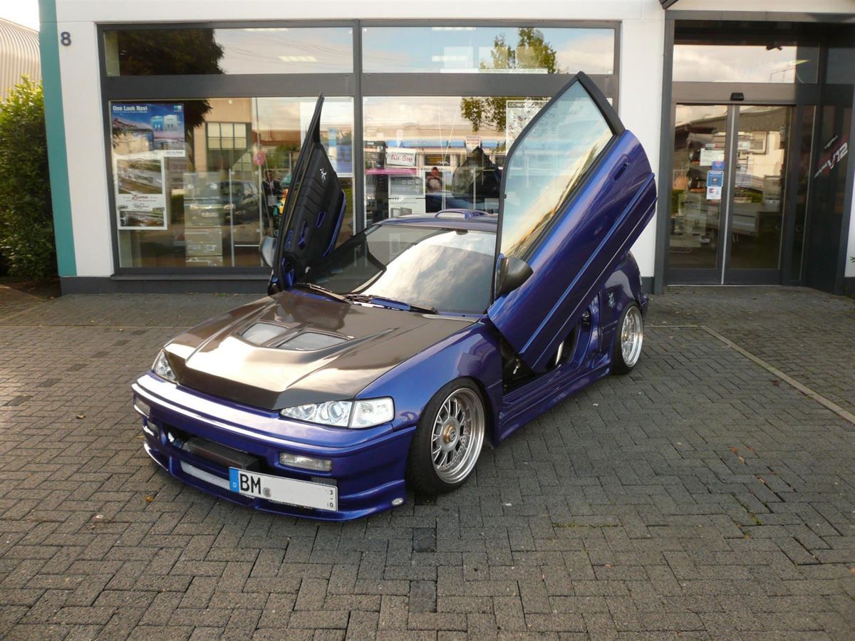 Ein blaues Auto mit einem Nummernschild, auf dem steht: