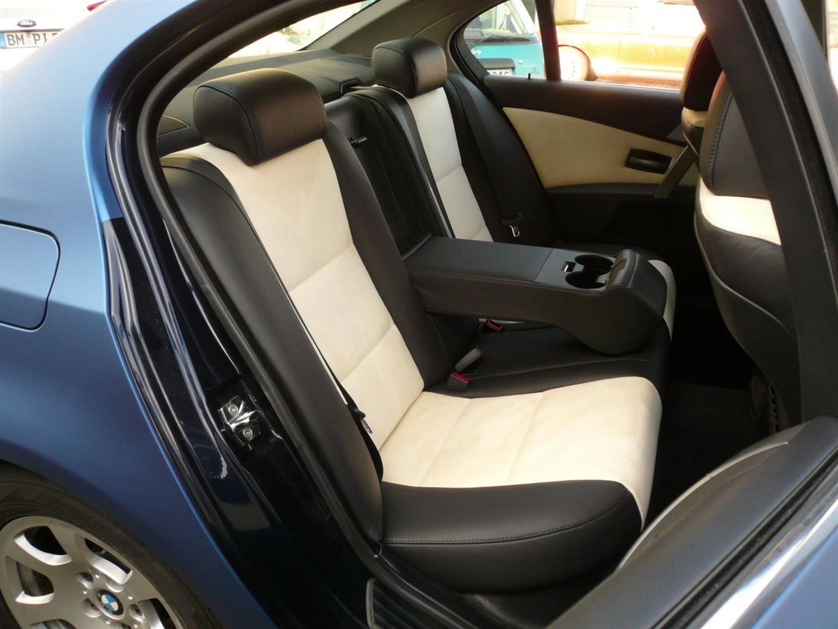 Der Rücksitz eines blauen Autos mit schwarzen und weißen Sitzen