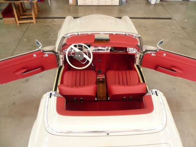 Ein weißes Auto mit roten Sitzen und einem Lenkrad