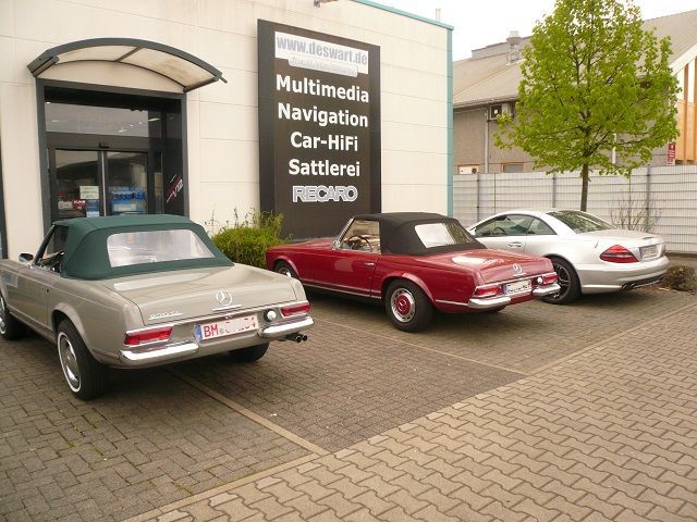 Drei Autos stehen vor einem Gebäude mit der Aufschrift „Multimedia-Navigation“