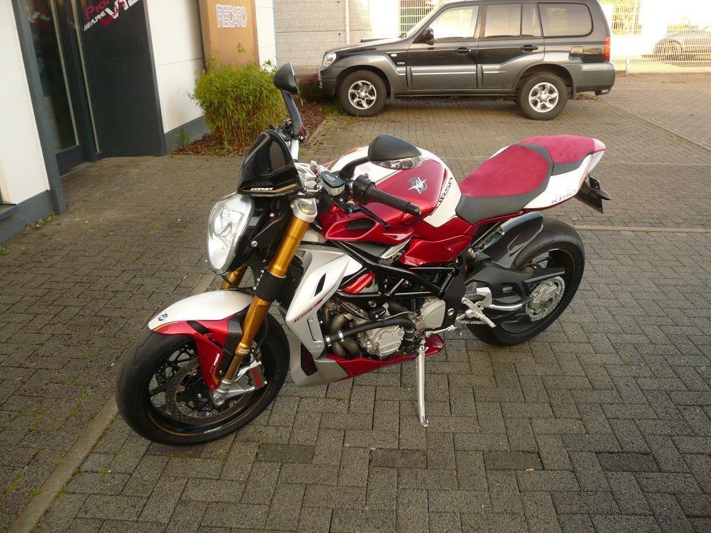 Ein rot-weißes Motorrad steht auf einem Parkplatz