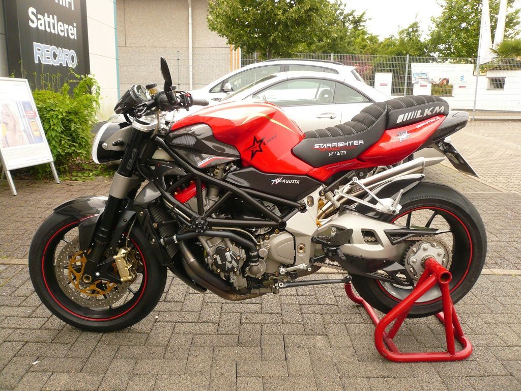 Ein rot-schwarzes Motorrad steht auf einem roten Ständer
