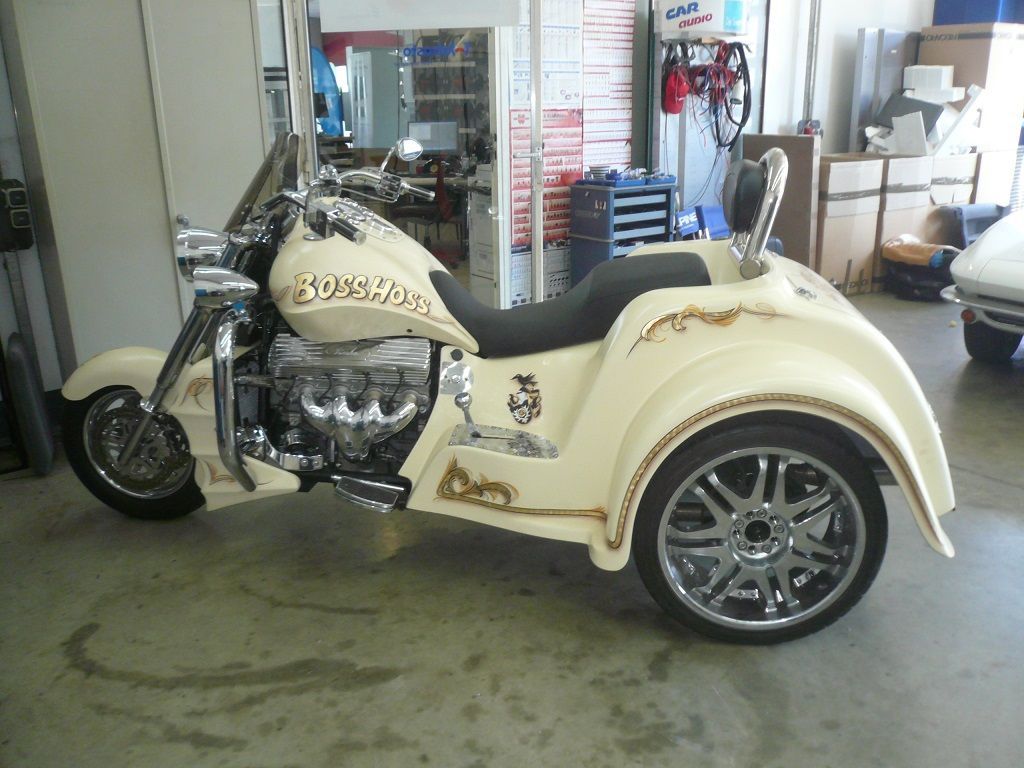 Ein weißes Motorrad mit Beiwagen steht in einer Garage