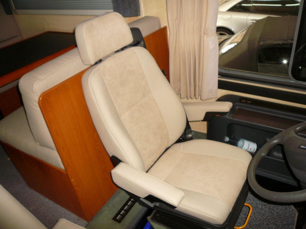 Ein hellbrauner Ledersitz in einem Auto mit Lenkrad