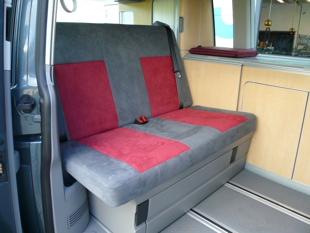 Die Rückbank eines Lieferwagens hat einen rot-grauen Sitzbezug