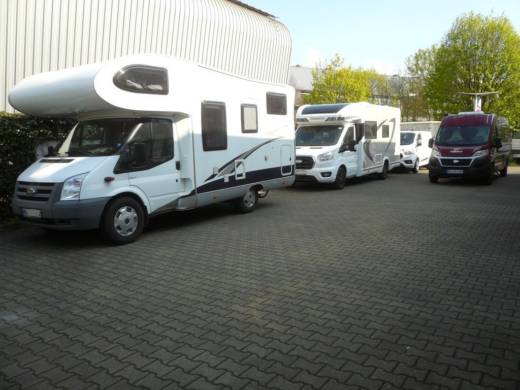 Eine Reihe von Wohnmobilen steht auf einem Parkplatz