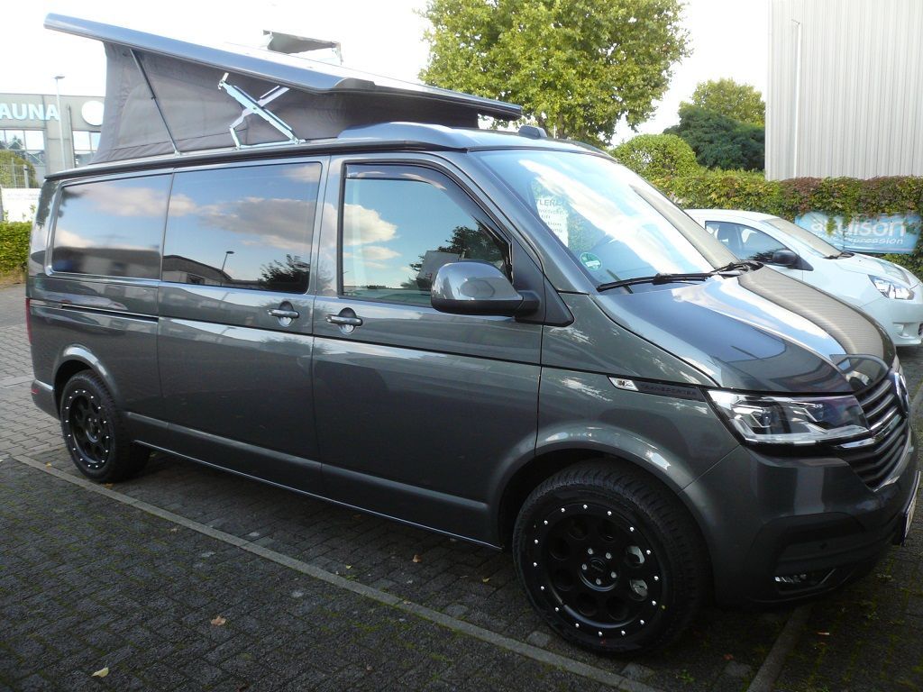 Ein schwarzer Van mit Aufstelldach steht auf einem Parkplatz