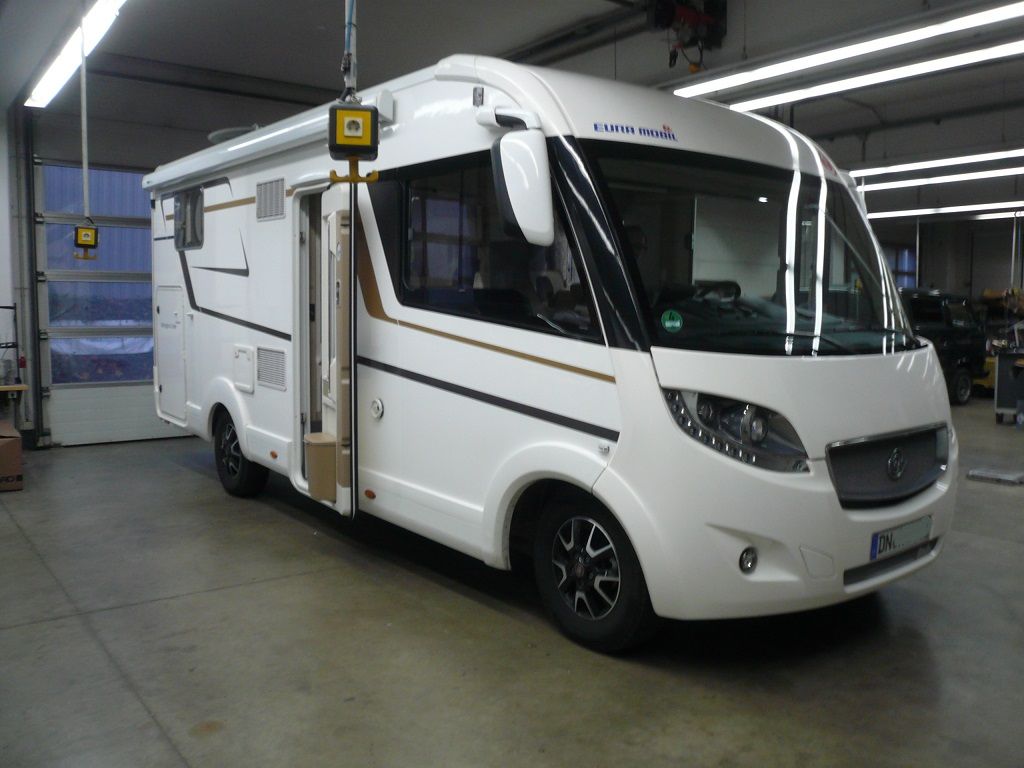 Ein großes weißes Wohnmobil steht in einer Garage