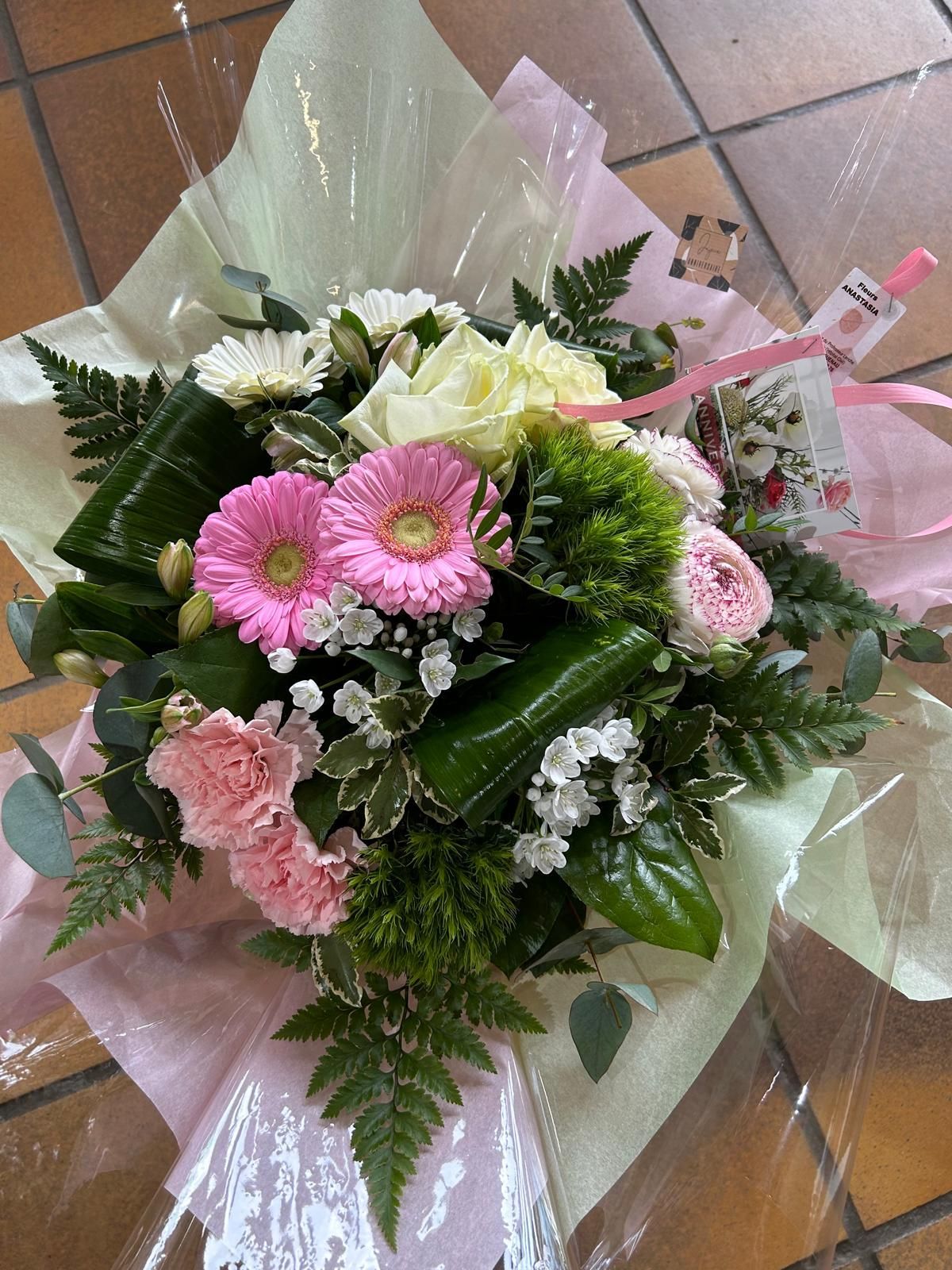 Bouquet en arrière-plan d'une paire de chaussons de bébé