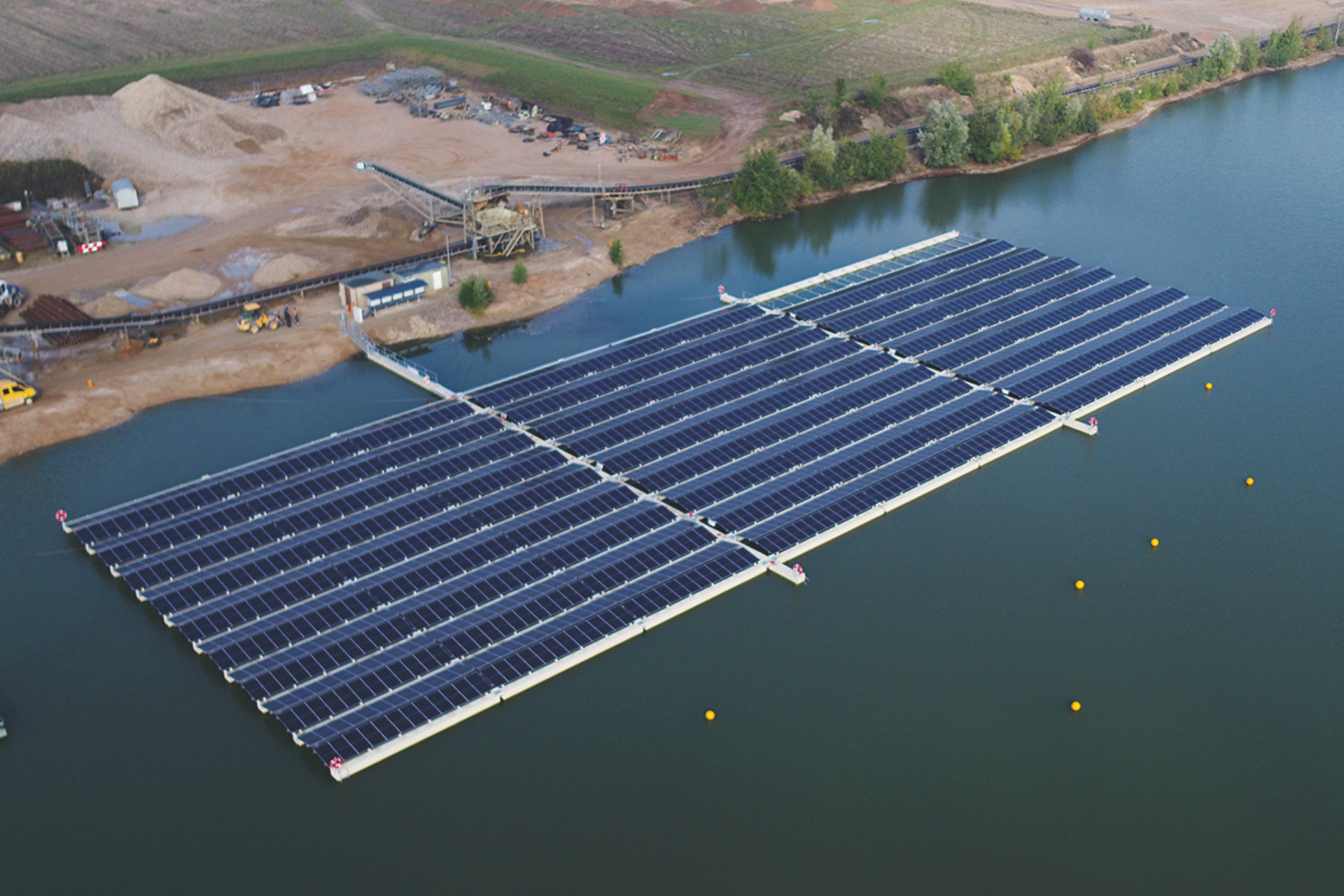 Schwimmende Solarpaneele auf einem Gewässer in Küstennähe.