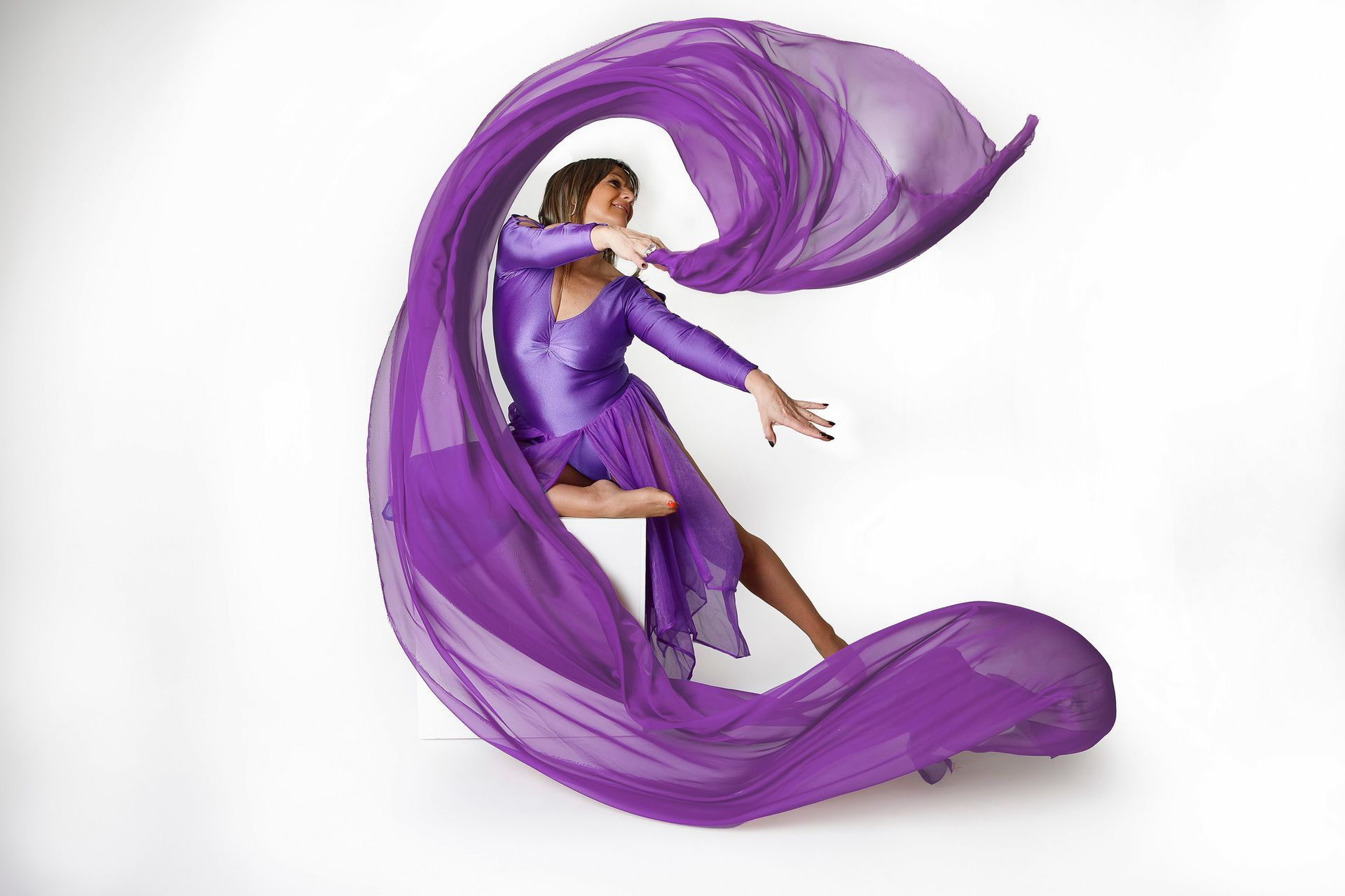 Una mujer con un vestido morado está envuelta en una tela morada.