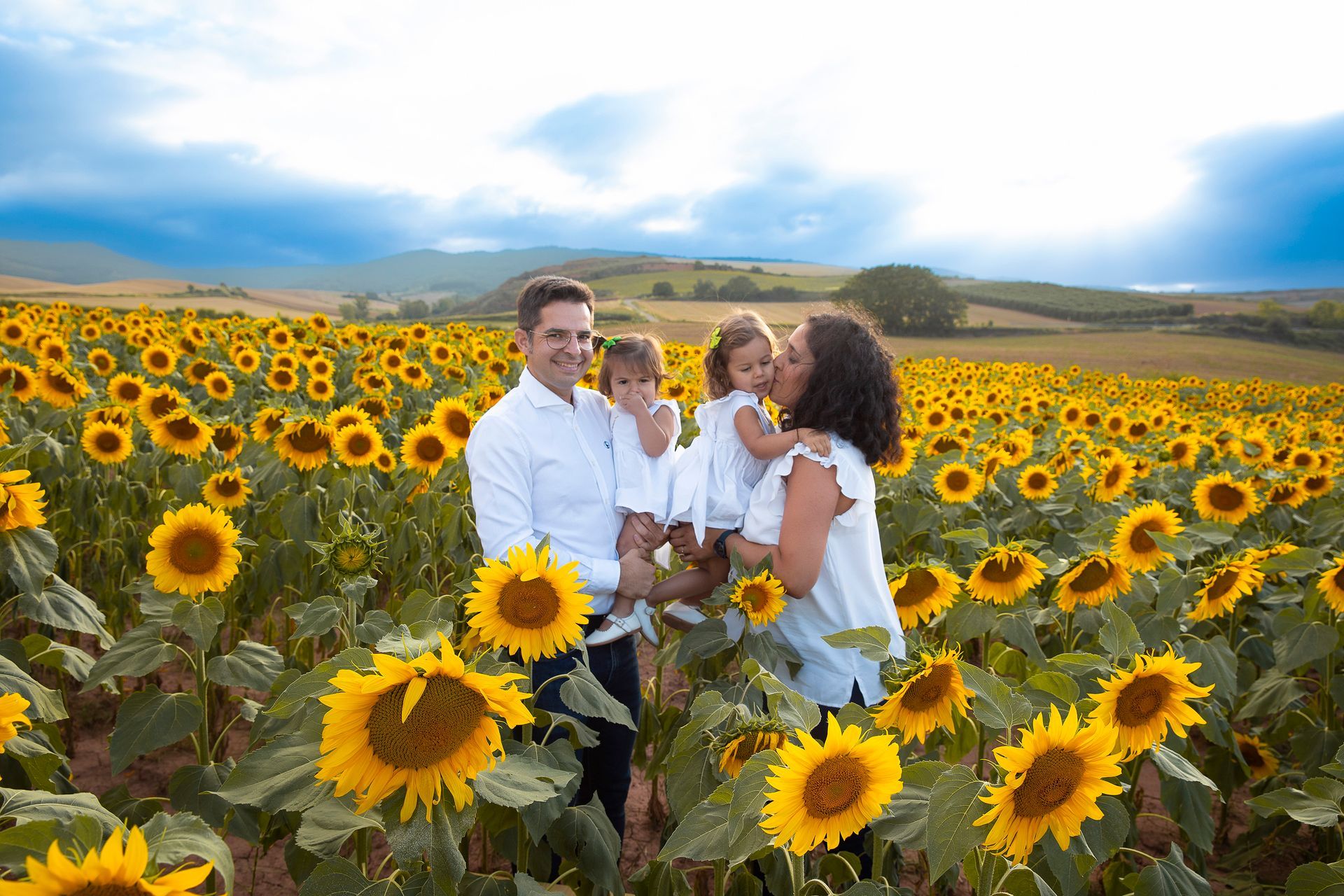 Una familia está parada en un campo de girasoles.