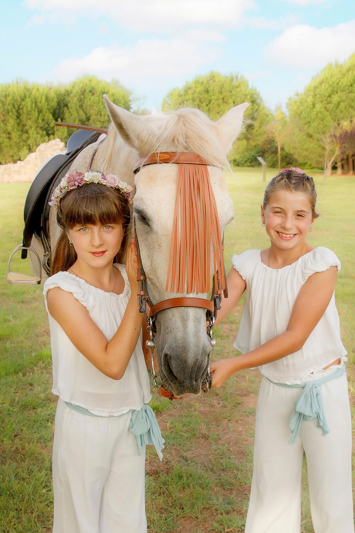 Dos niñas paradas junto a un caballo en un campo