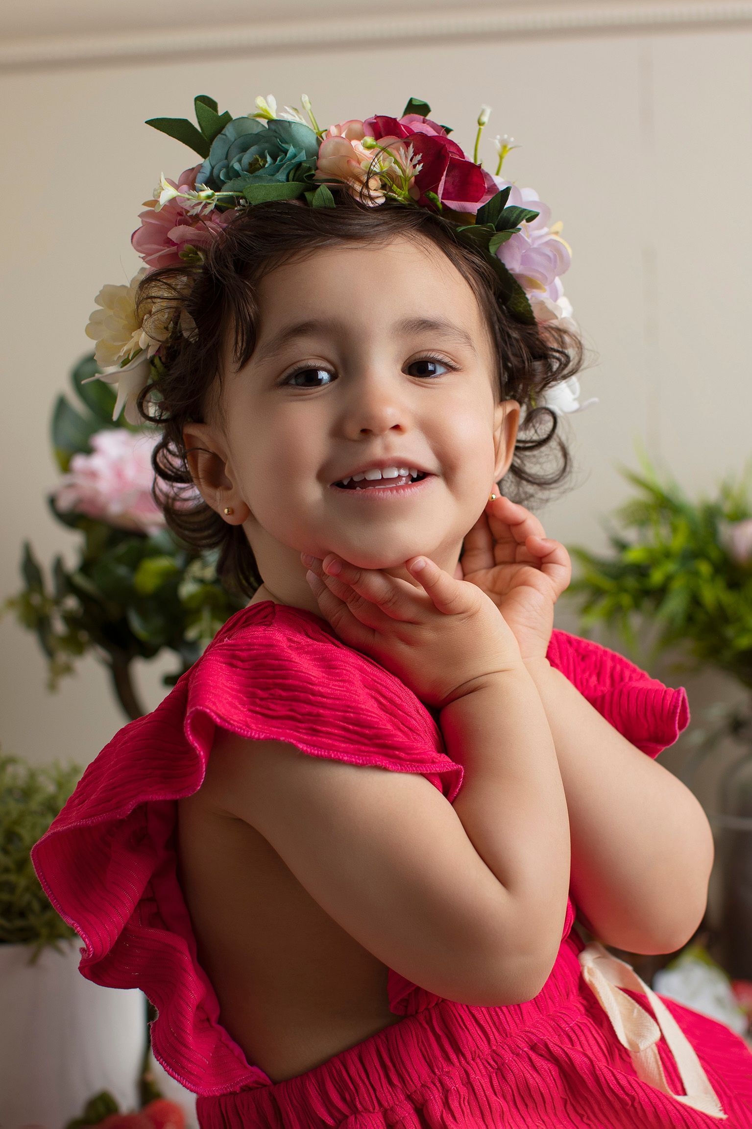 Una niña que lleva un vestido rosa y una corona de flores.