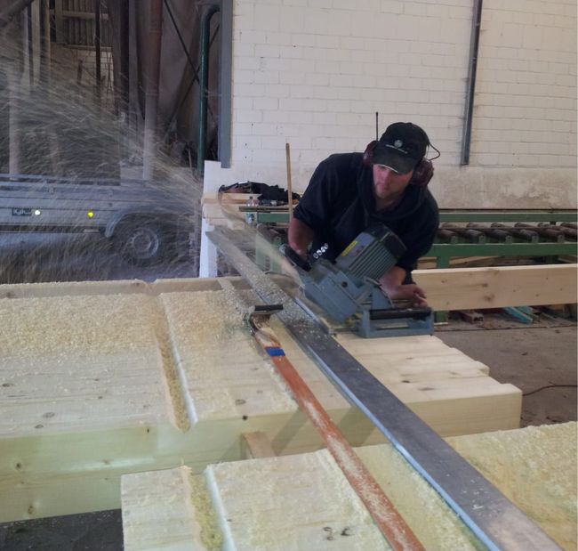 Ein Mann benutzt eine Maschine, um ein Stück Holz zu schneiden