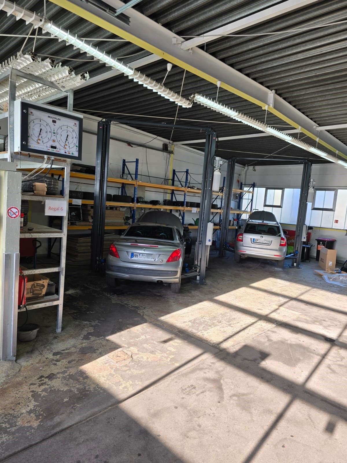 Zwei Autos sind in einer überdachten Garage geparkt.