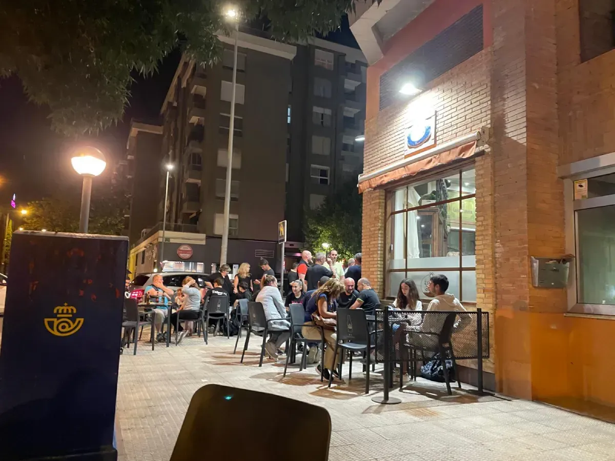 Interior de un pub con una mesa de barril de madera en primer plano, con carteles de cerveza enmarcados en una pared