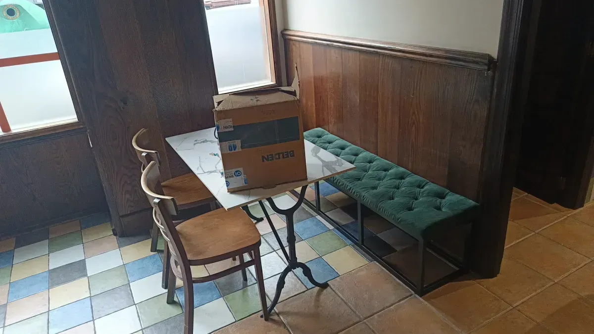 Un cartel ovalado de color azul sobre una pared de ladrillos dice 