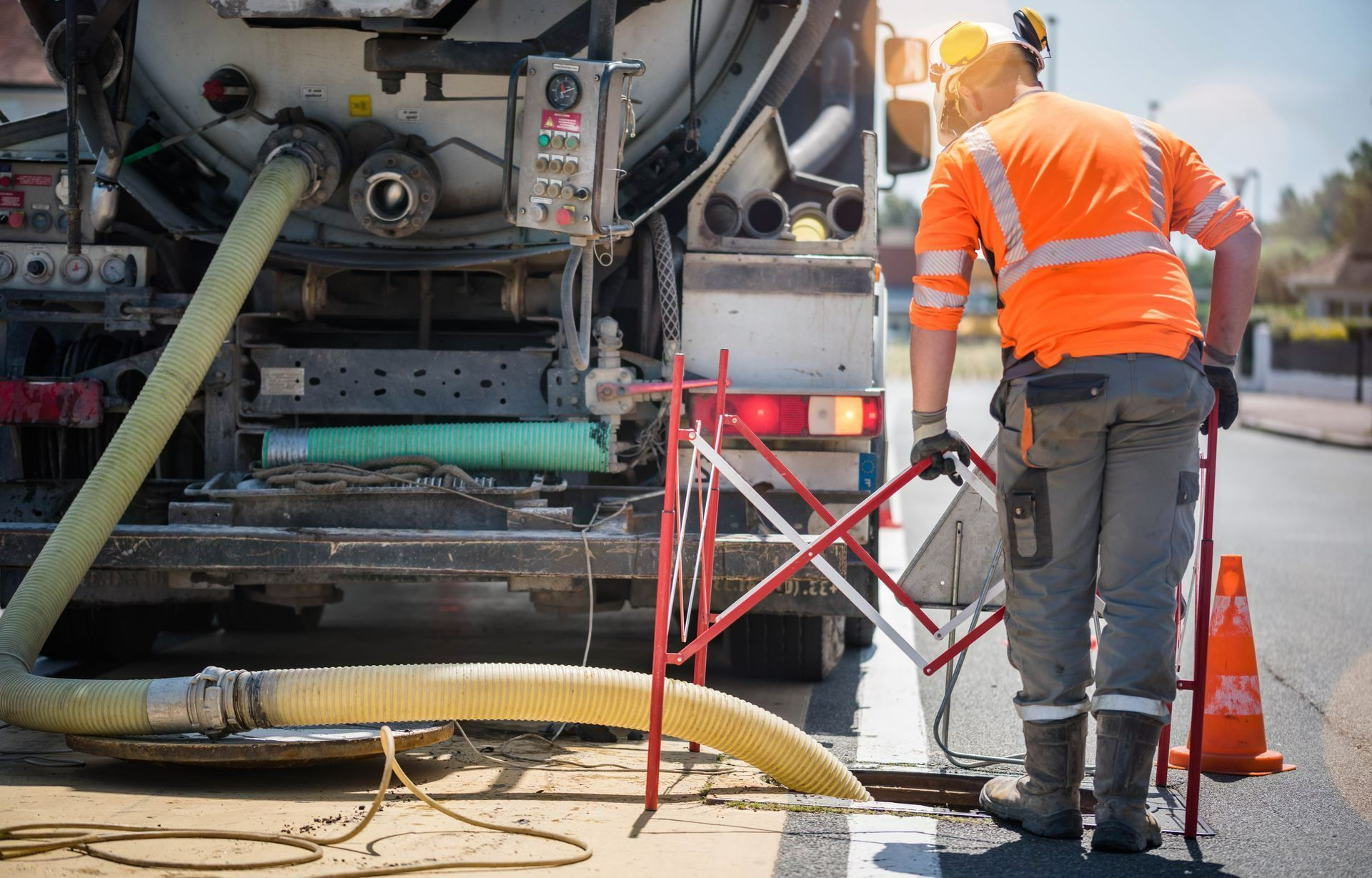 Un camion et un tuyau dans une bouche d'égout sur la voie publique