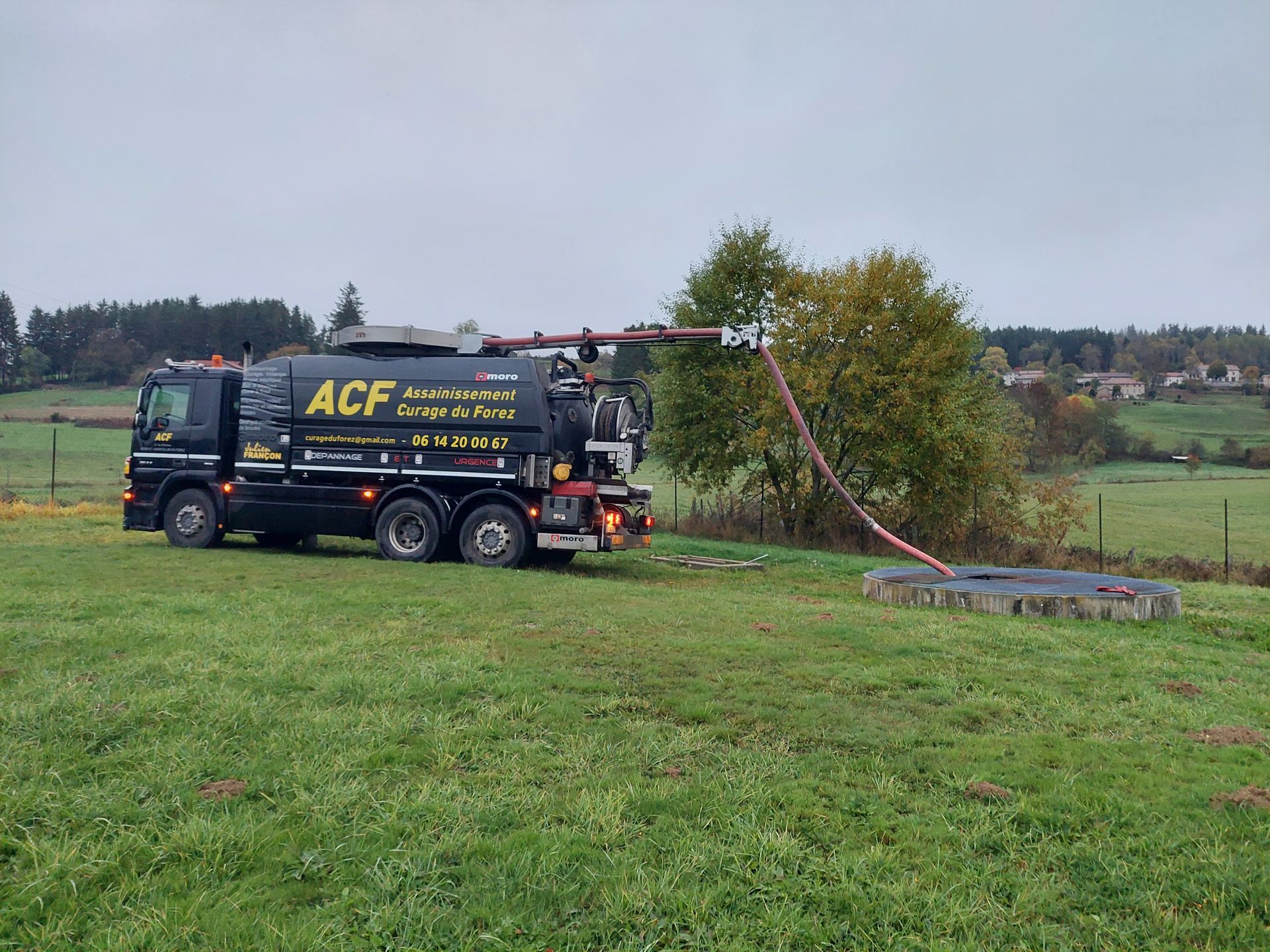 Pompage d'une fosse septique avec un camion noir ACF