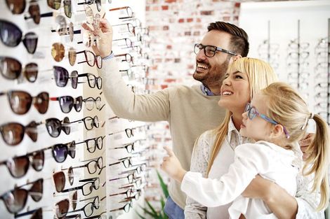 Una familia está mirando gafas de sol en una óptica.