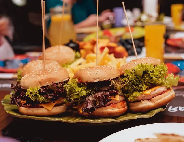Un plato de hamburguesas y patatas fritas en una mesa.