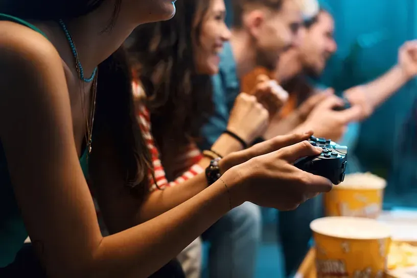 Un grupo de personas está sentada alrededor de una mesa jugando un videojuego.