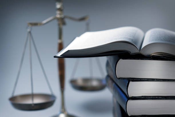 Balance de la justice et une pile de livres de droit.