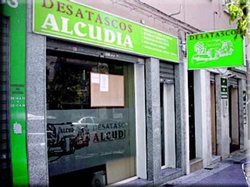 Un escaparate con un cartel verde que dice desatascos alcuidia