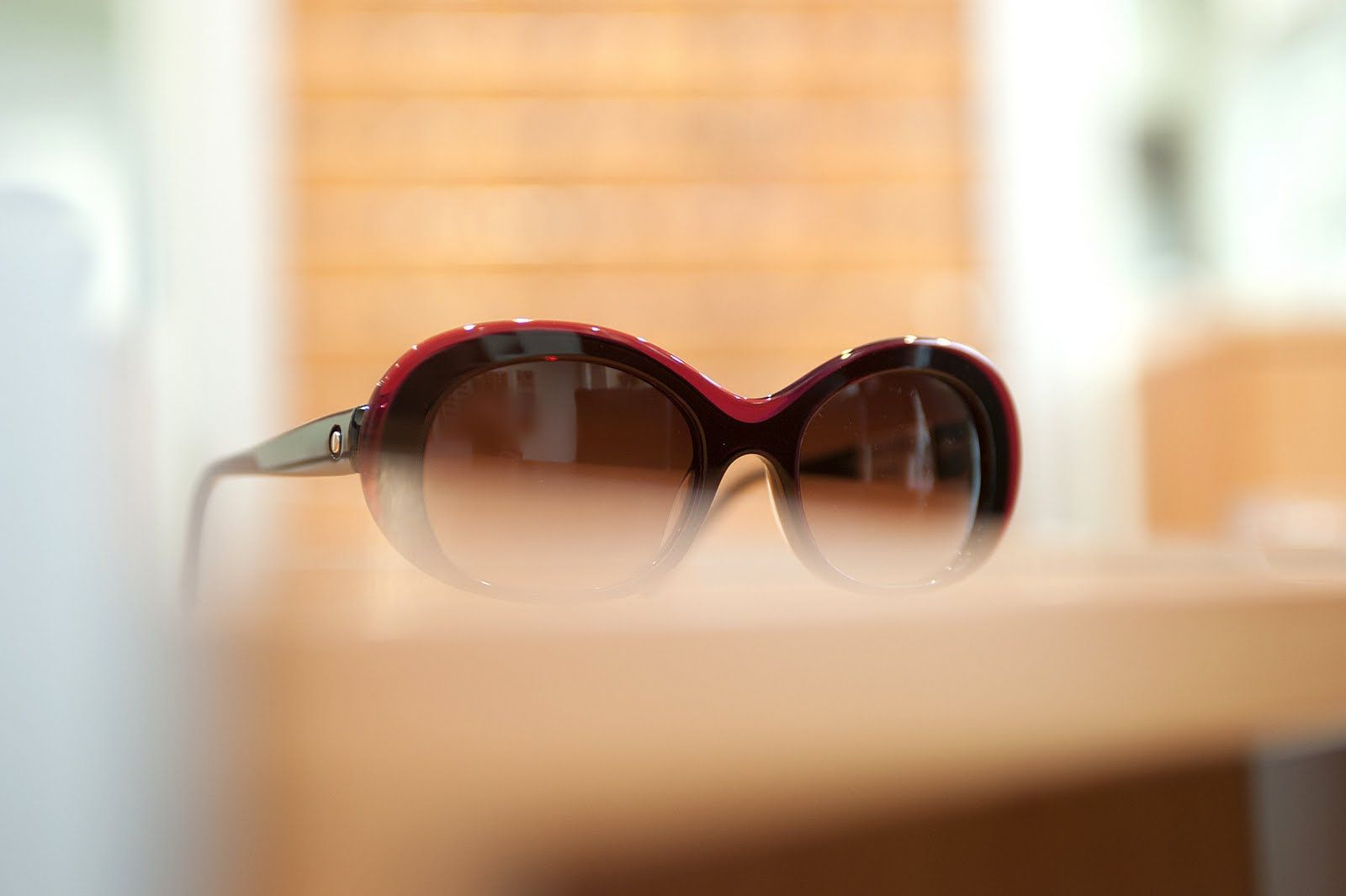 Eine Sonnenbrille liegt auf einem Holztisch.