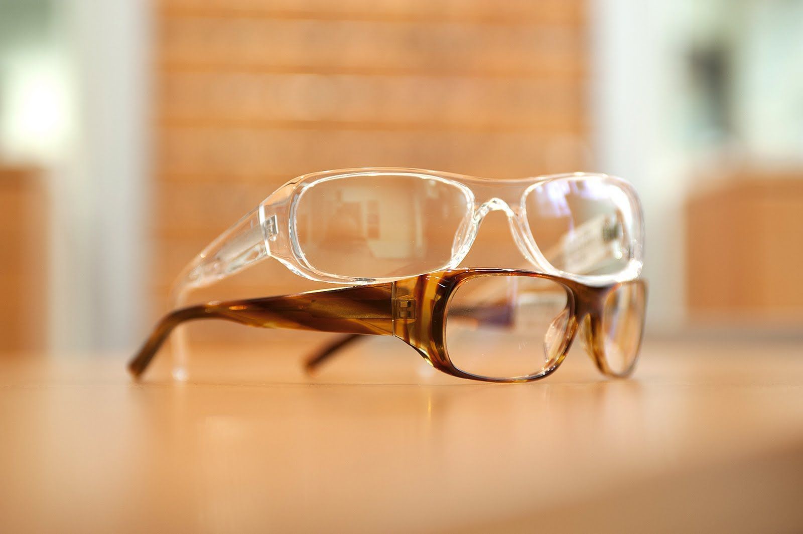 Auf einem Tisch sind zwei Brillen übereinander gestapelt.