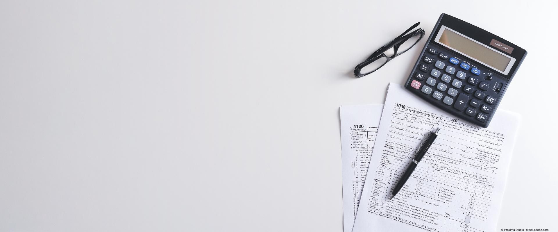 Dokumente mit Taschenrechner liegen auf einem Tisch