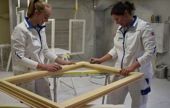 Zwei Mitarbeiterinnen der Malergeschäft R. & M. Schuler GmbH arbeiten an einem Rahmen
