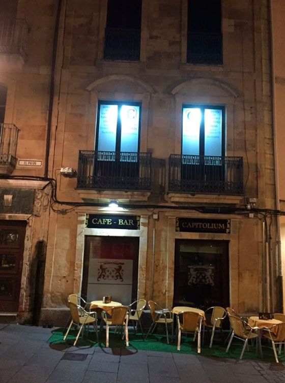 Un edificio con mesas y sillas al frente que dice cafetería bar.