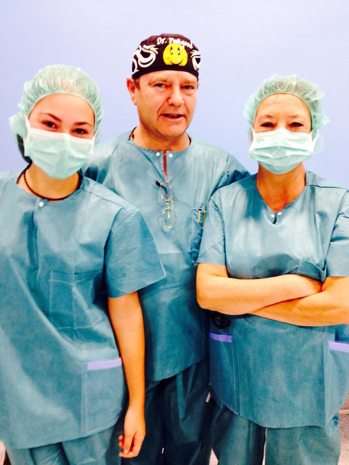 Un grupo de médicos vestidos con uniformes y mascarillas posan para una fotografía.