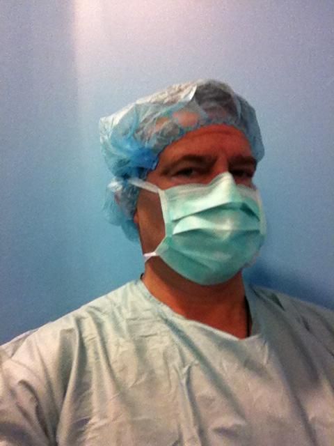 Un hombre que lleva una bata quirúrgica y una mascarilla.