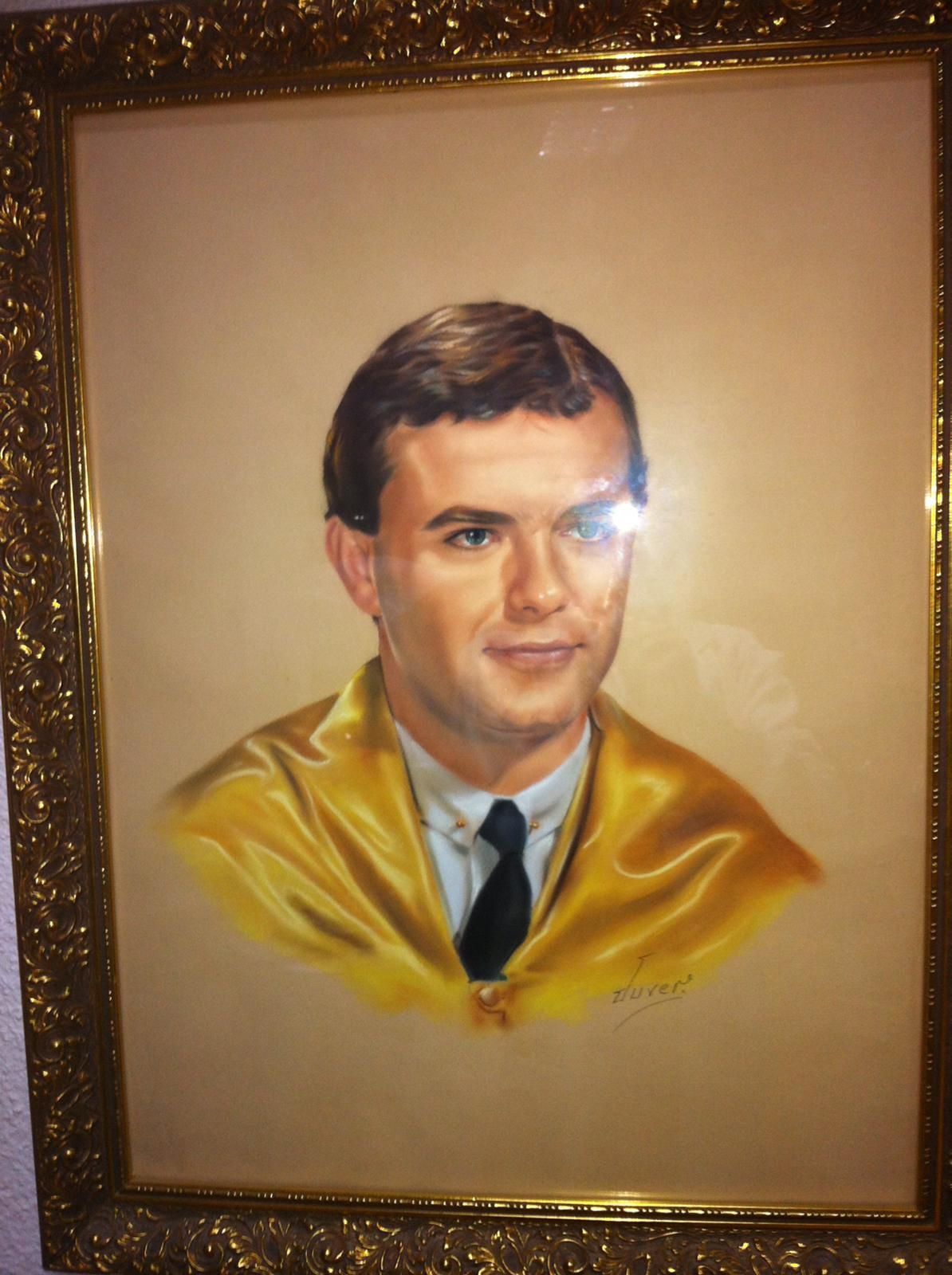 Un retrato enmarcado de un hombre con una chaqueta amarilla y corbata.