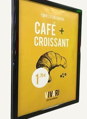 Un cartel publicitario amarillo enmarcado de Vivari Coffee & Bakery que anuncia una oferta de desayuno con café y croissant por 1,70 €.
