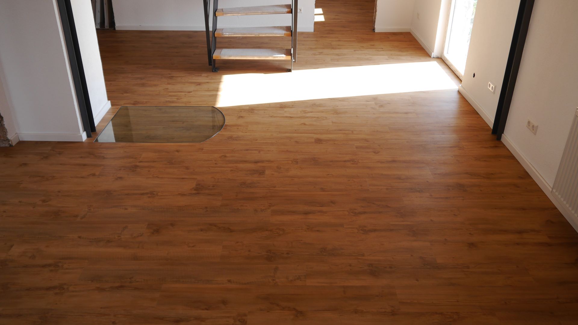 Ein Raum mit Holzboden und Wendeltreppe