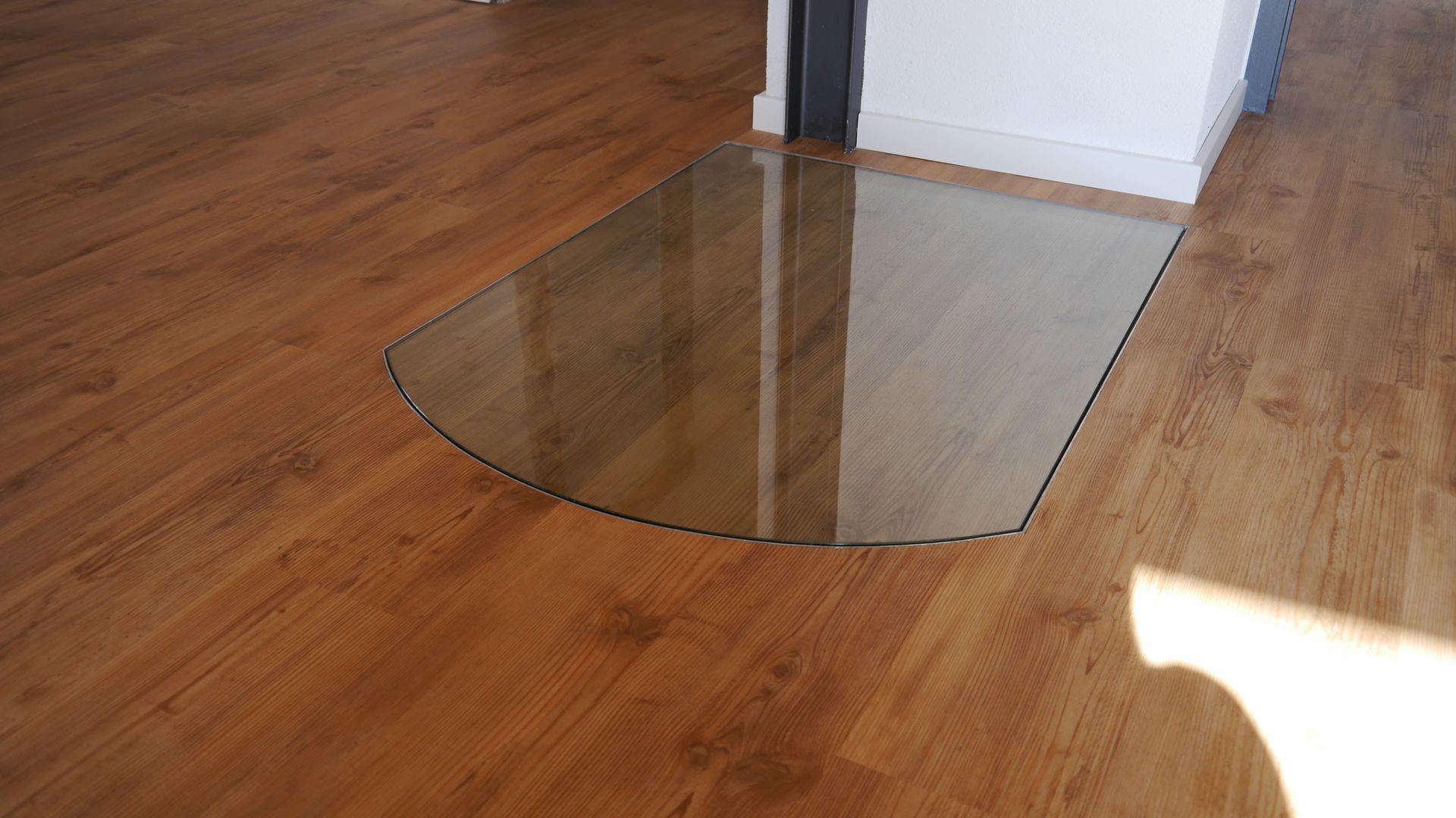 Ein Holzboden mit einer Glasmatte darauf.