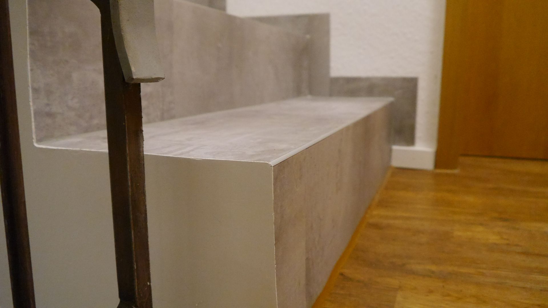 Eine Treppe mit Holzgeländer und Holzboden in einem Flur.