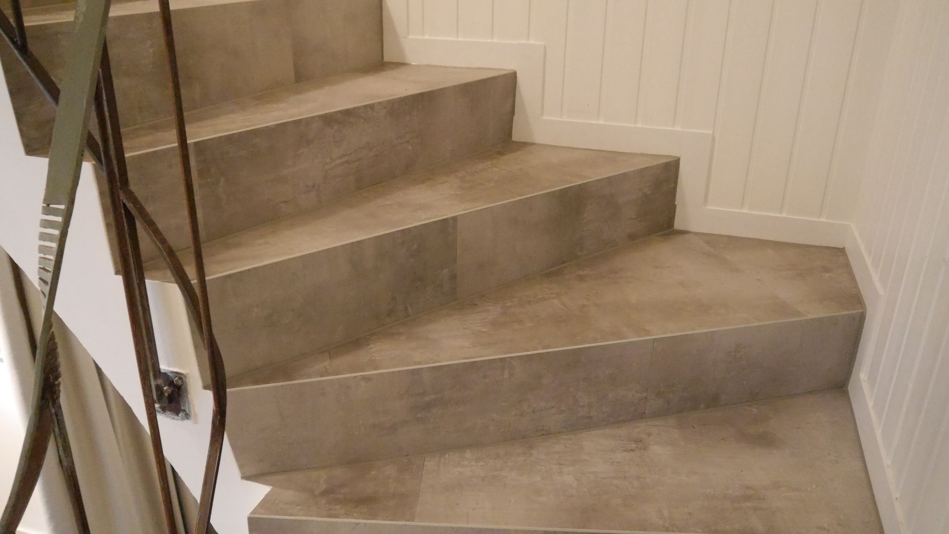 Eine Nahaufnahme einer Treppe mit einem Metallgeländer.