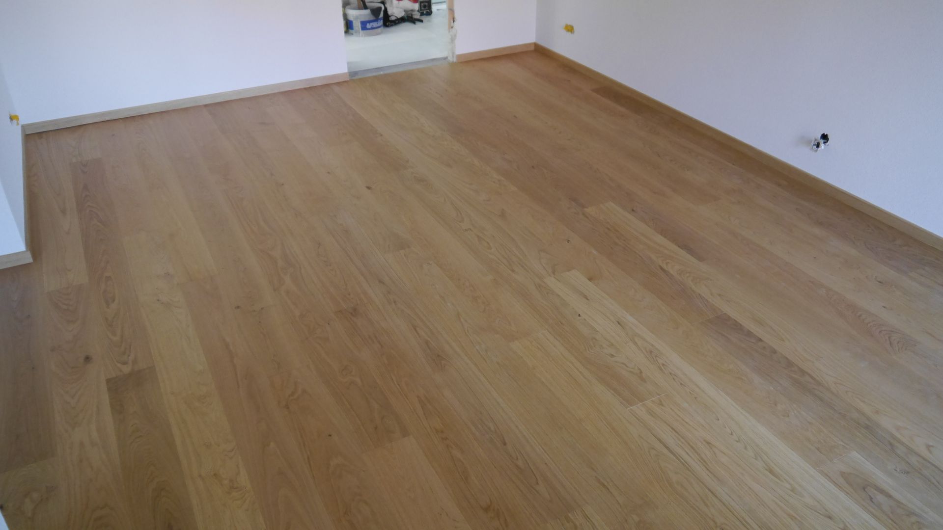 Ein Raum mit Holzboden und weißen Wänden.