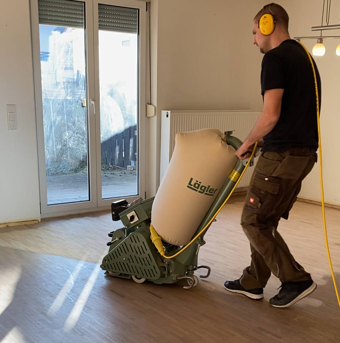 Ein Mann mit Kopfhörern benutzt ein Gerät, auf dem „Größer“ steht