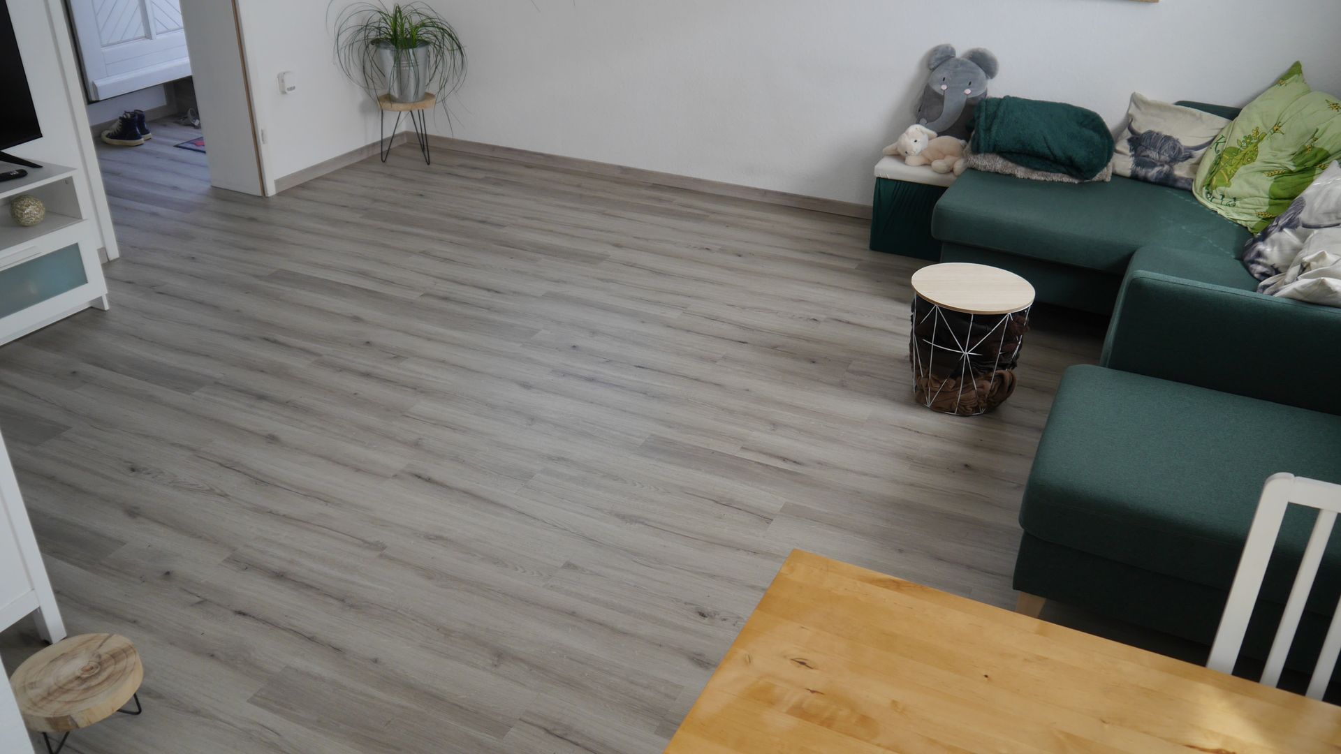 Ein Wohnzimmer mit einem grünen Sofa und einem Holztisch.