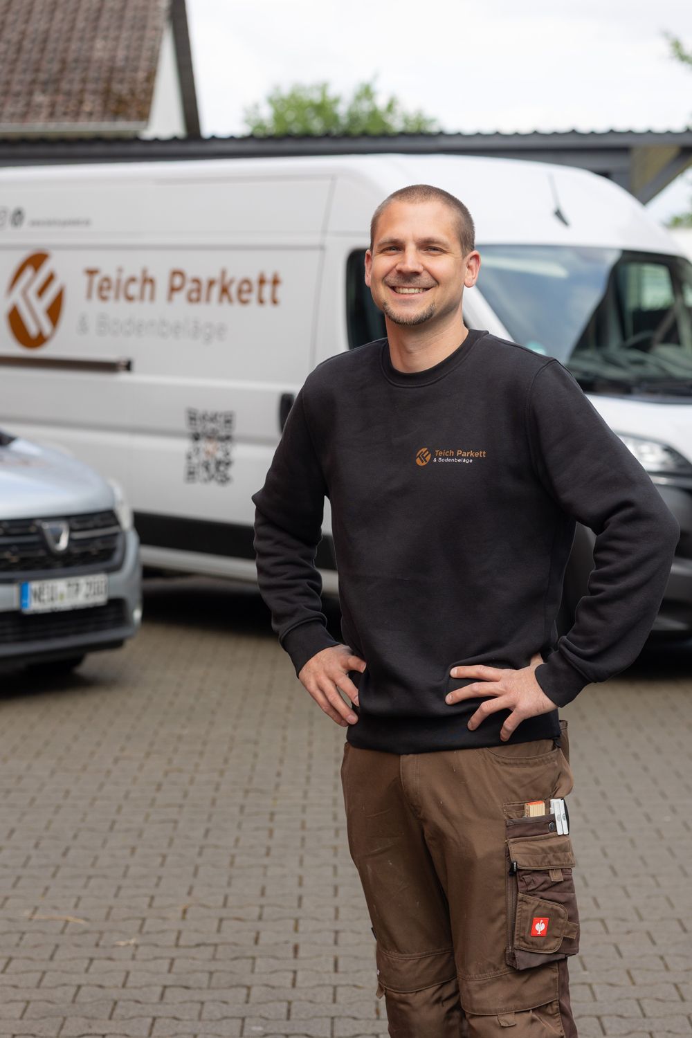 Ein Mann mit Bart und schwarzem Hemd lächelt in die Kamera.