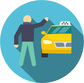 Una persona con chaqueta oscura y pantalones claros está de pie junto a la carretera, levantando un brazo para hacer señas a un taxi amarillo.