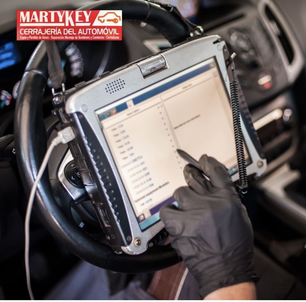 Un mecánico utiliza una tableta de diagnóstico dentro de un automóvil, probablemente para reparaciones automotrices.